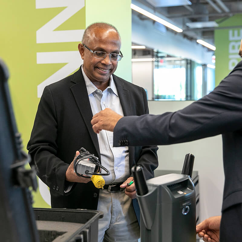 A man with glasses holds a piece of tech equipment